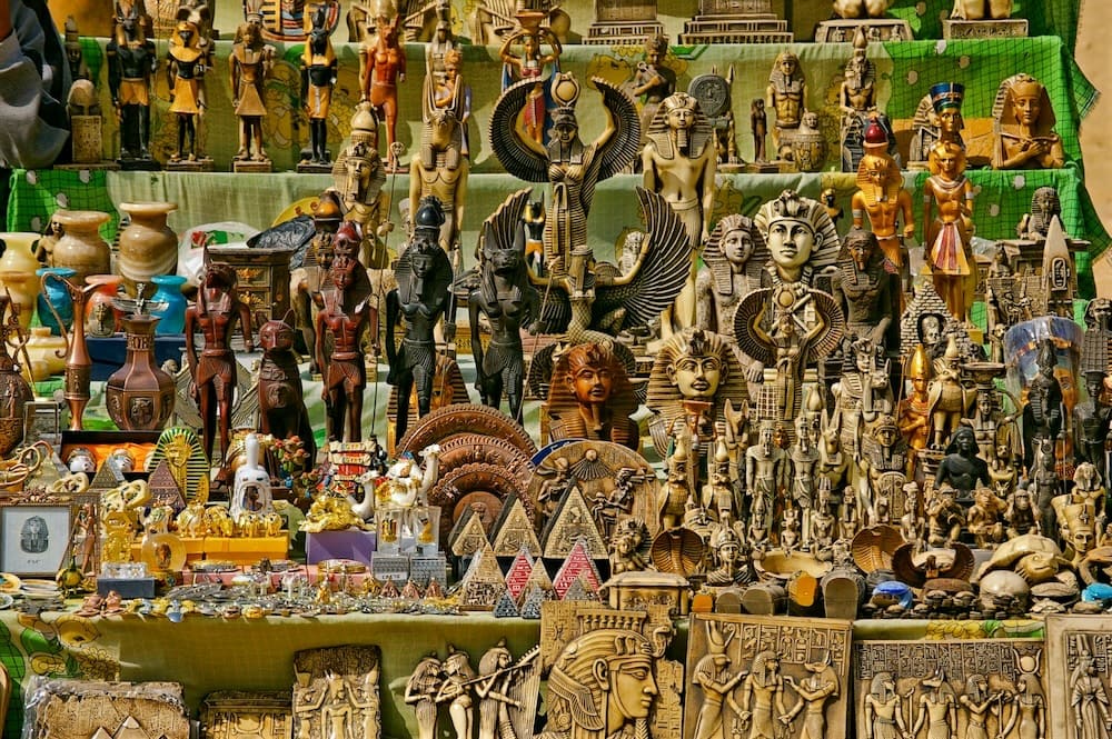 An array of colorful Egyptian souvenirs and statuettes displayed at a market stall.
