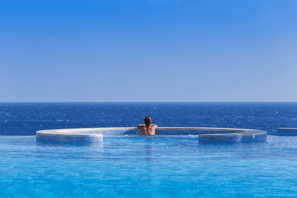 Luxurious beachfront view of The Oberoi Beach Resort, Sahl Hasheesh with clear turquoise waters and a golden sandy beach under a bright blue sky.