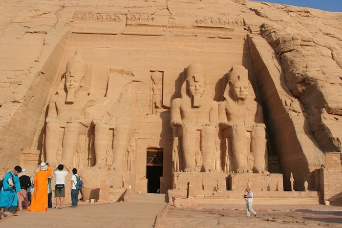 Entrance of Abu Simbel with statues of Ramses II and visitors.
