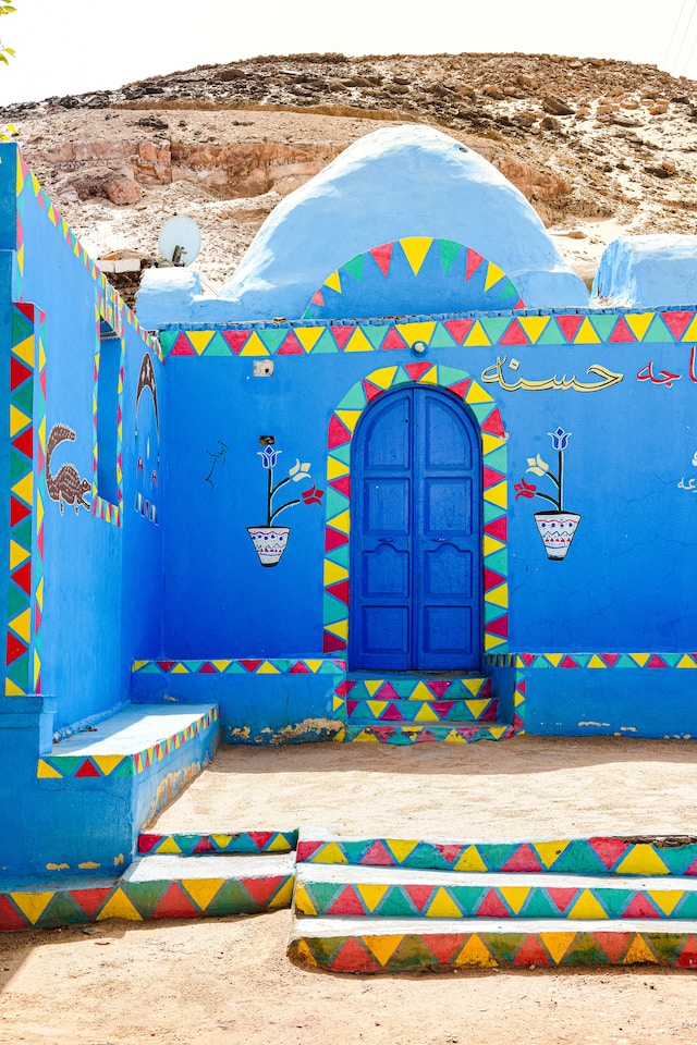 A strikingly painted Nubian doorway with intricate patterns and a welcoming message.