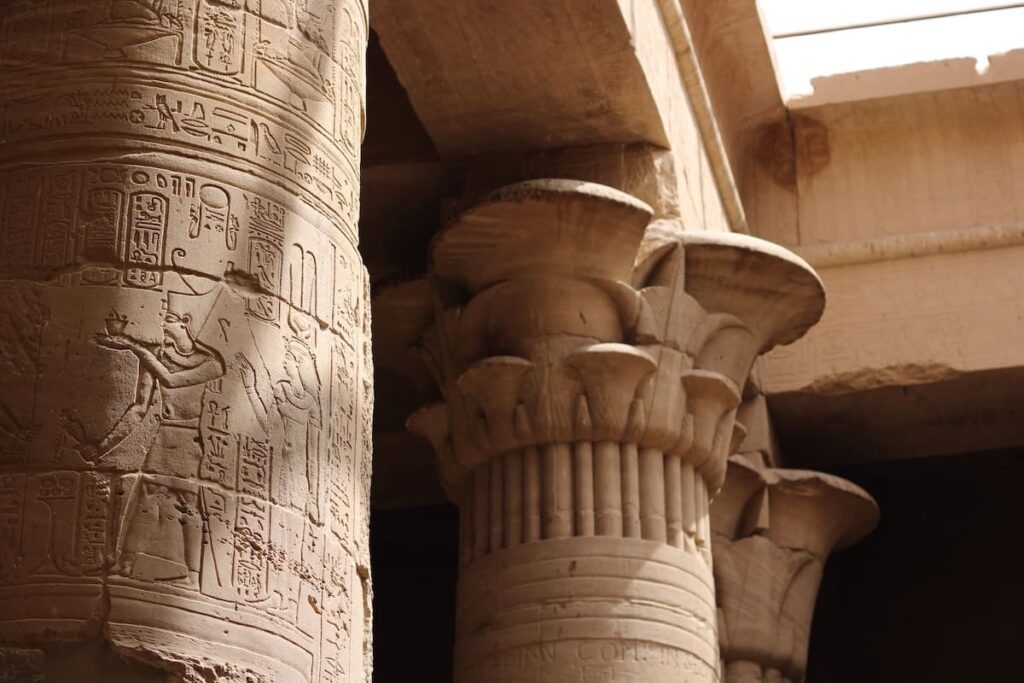 View of the ancient Dendera Temple in Qena, Egypt, showcasing detailed carvings and hieroglyphs on massive stone pillars