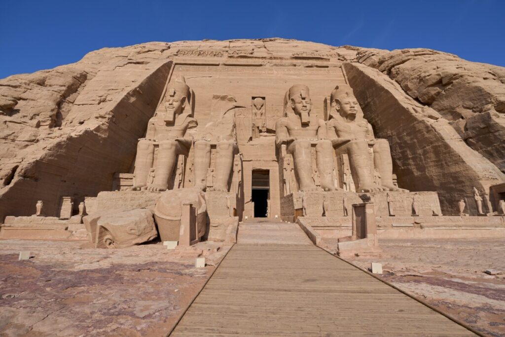The front view of Abu Simbel's main temple with four giant statues of Ramses II.