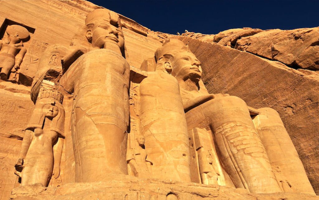 Golden sunlight illuminates the colossal statues of Abu Simbel.