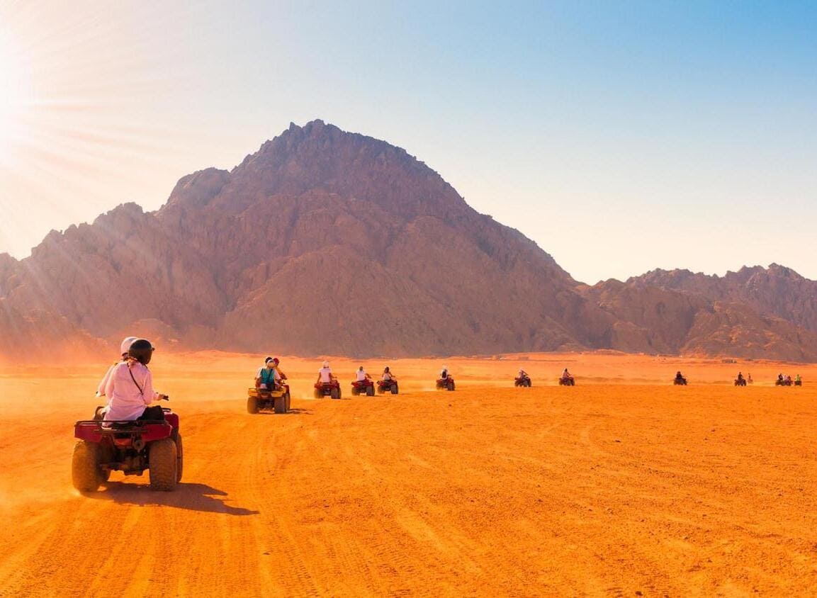 travelers riding quad bike in hurghada's desert