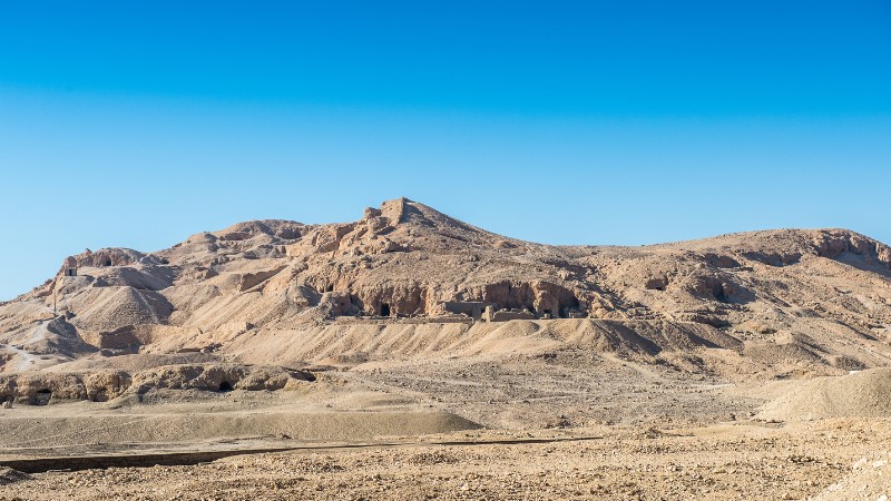 "Barren hills under the clear blue sky in the Egyptian desert."