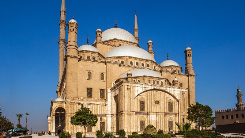 "The Mosque of Muhammad Ali in Cairo against a clear blue sky."