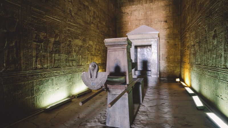 "Inner chamber of an Egyptian temple with a statue of a deity."