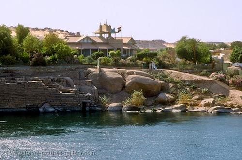 View of Aswan Museum by the Nile, amidst lush greenery and calm waters.