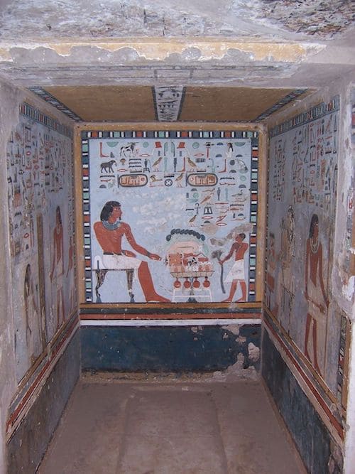 Ancient Egyptian tomb with colorful wall paintings depicting historical scenes.