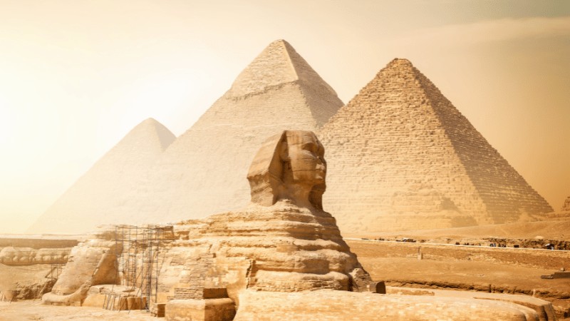 "The Great Pyramids of Giza and the Sphinx under a golden sky."