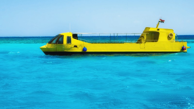 "Yellow semi-submersible tourist boat floating on clear blue waters"