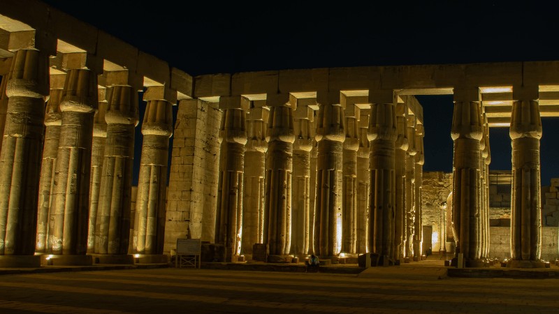 "Nighttime view of the lit columns of Karnak Temple in Luxor."