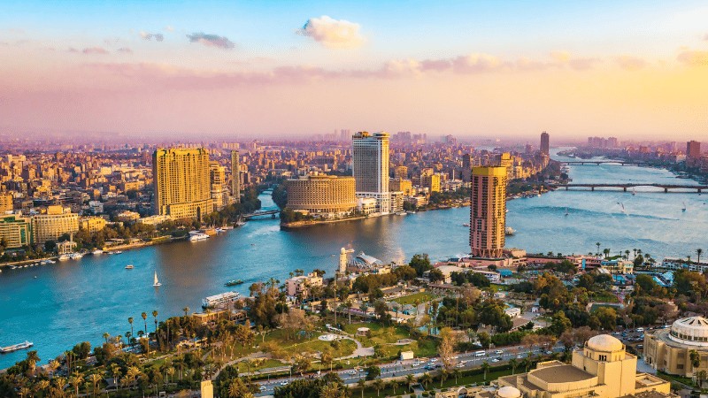 "Aerial view of Cairo's cityscape with the Nile River at sunset."