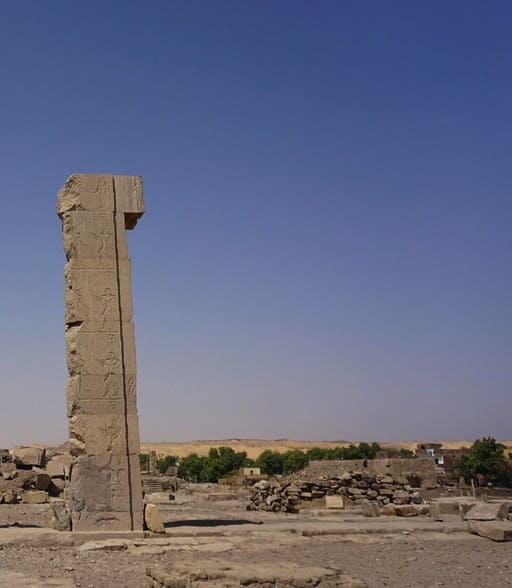A solitary ancient pillar stands against the desert backdrop in Aswan.