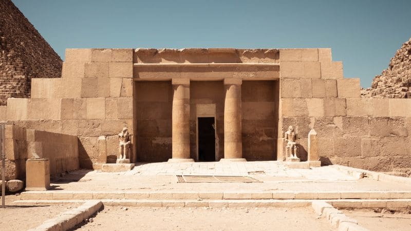 Ancient Egyptian temple entrance with statues.