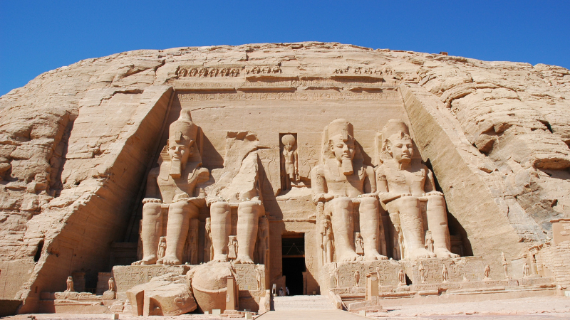 "The imposing facade of Abu Simbel, with four seated statues of Ramses II."