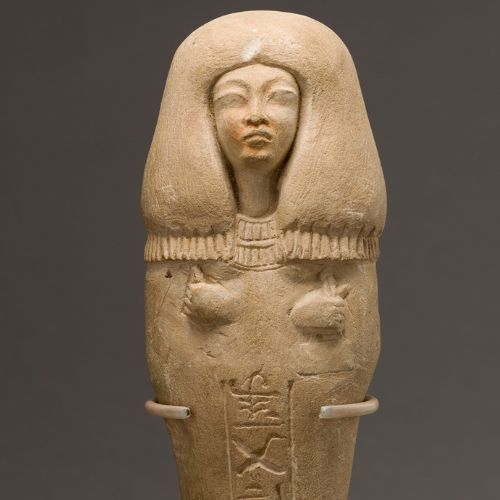 An Egyptian sandstone carving of a female figure with a headdress, from antiquity