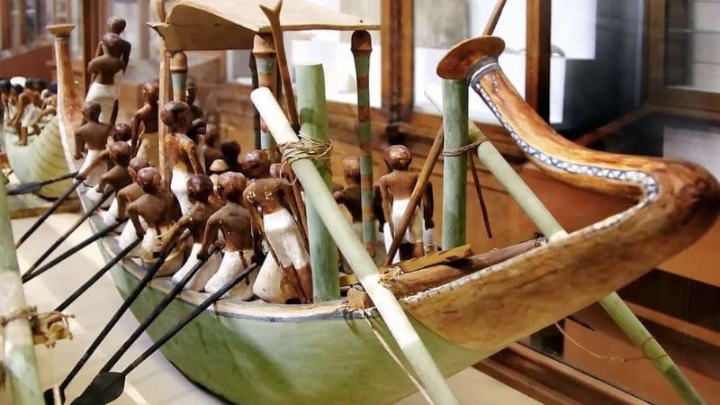 Model of an ancient Egyptian boat with figurines.