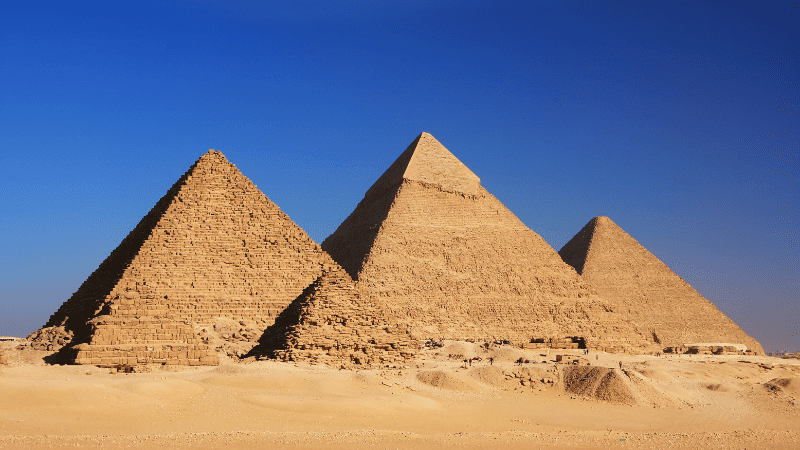 The three pyramids of Giza under a clear blue sky