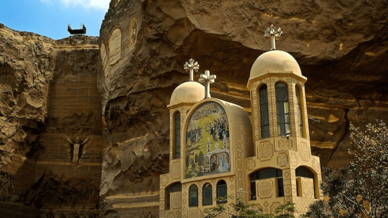 A modern church built into a cliffside with religious murals