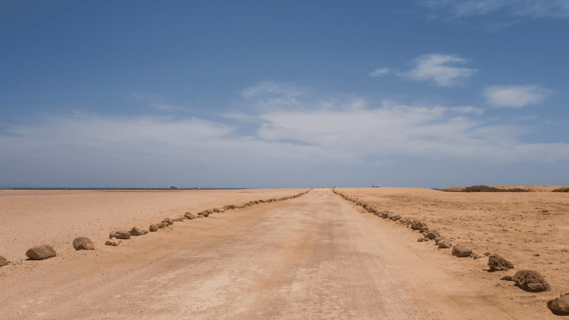 Desert road under a blue sky.