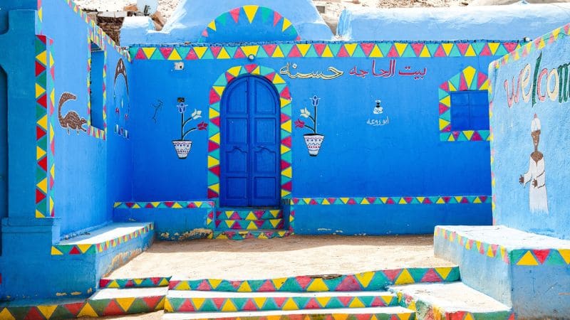 Bright blue Nubian village house with colorful decorations.