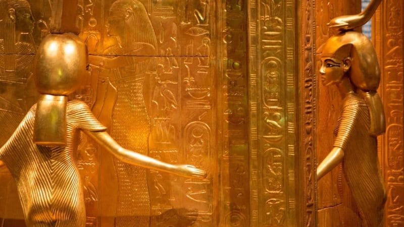 Golden Egyptian artifacts with hieroglyphs.