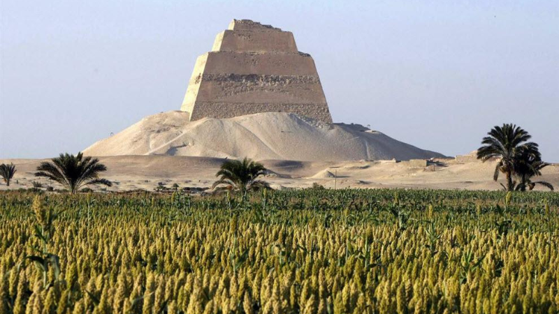 The Bent Pyramid of Dahshur with a lush green field in the foreground