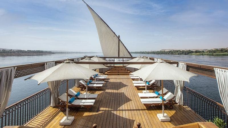 The deck of a Nile cruise boat, with loungers and a sail, inviting guests to relax as they sail.
