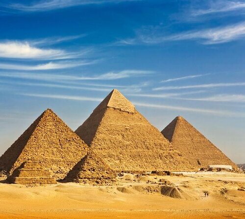 Three ancient pyramids rising from the desert sands under a clear blue sky in Giza, Egypt