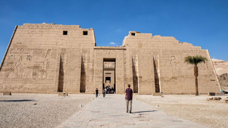 Visitors walking towards the grand entrance of the Edfu Temple