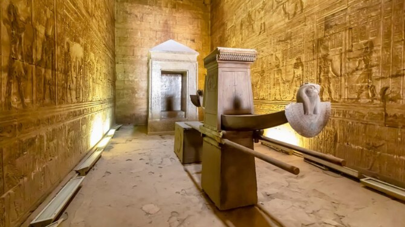 Interior of an Egyptian temple with a sacred boat shrine and detailed wall carvings