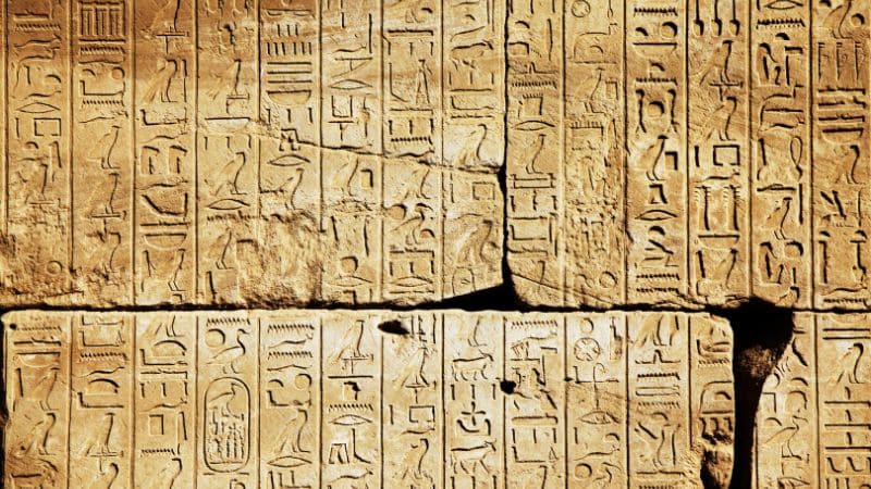 Ancient Egyptian hieroglyphic carvings on a stone wall.