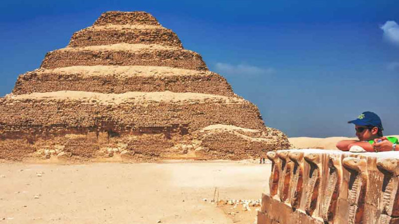 A man rests at a viewpoint before the Step Pyramid of Djoser