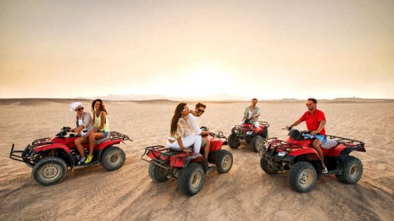 A group of friends on ATVs enjoys a fun ride in the vast Egyptian desert.