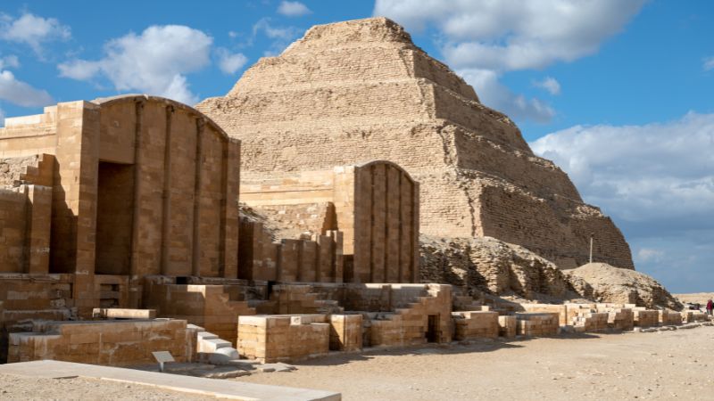 "Ancient step pyramid of Djoser surrounded by ceremonial structures in Egypt."