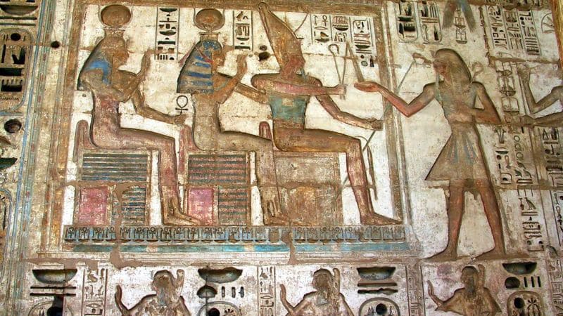 Colorful ancient Egyptian hieroglyphs and figures on a temple wall.