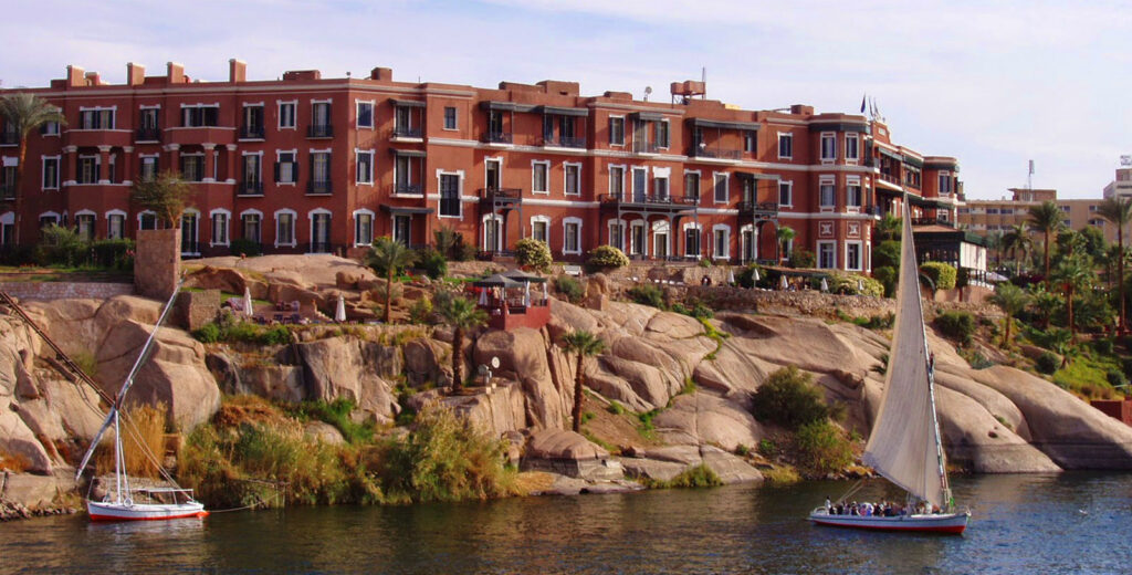 Majestic view of the historic Old Cataract Hotel in Aswan, Egypt, with its grand architecture and a stunning backdrop of the Nile River