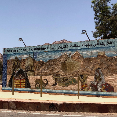 Mural depicting Saint Catherine City with mountains, a camel, and cultural icons.