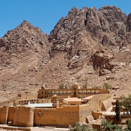 St. Catherine's Monastery at the base of a rugged mountain under a clear blue sky