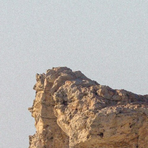 Close-up image of a weathered rock formation against a clear sky