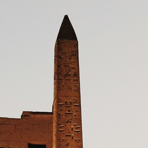 An obelisk with hieroglyphic engravings against a twilight sky