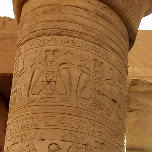Close-up of an ancient Egyptian column covered in intricate hieroglyphics