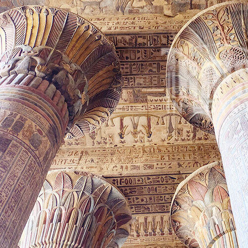 Ancient, intricately decorated columns at the Temple of Esna, Egypt.