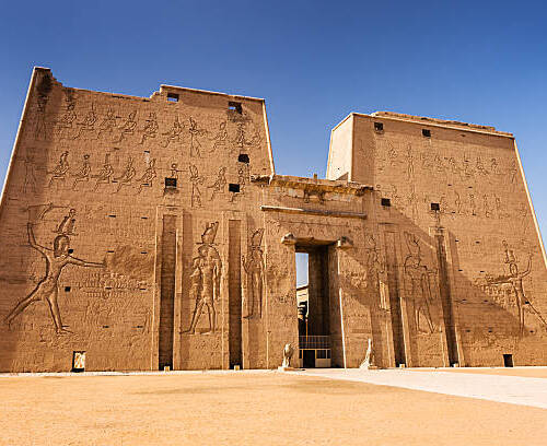 The front view of Edfu Temple in Egypt, showcasing ancient hieroglyphs and colossal statues.