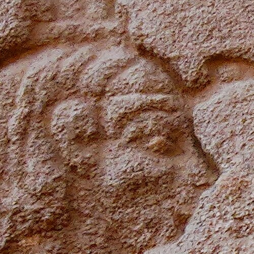 Close-up of an ancient stone carving depicting a human face.