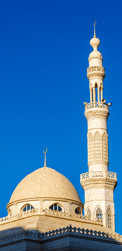 Historic mosque with intricate architecture and a prominent dome under a clear sky