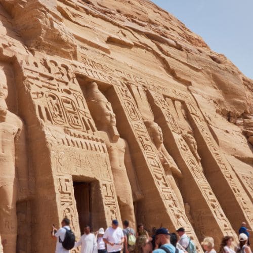 Visitors at the entrance of the Abu Simbel temple, with colossal statues of Ramses II