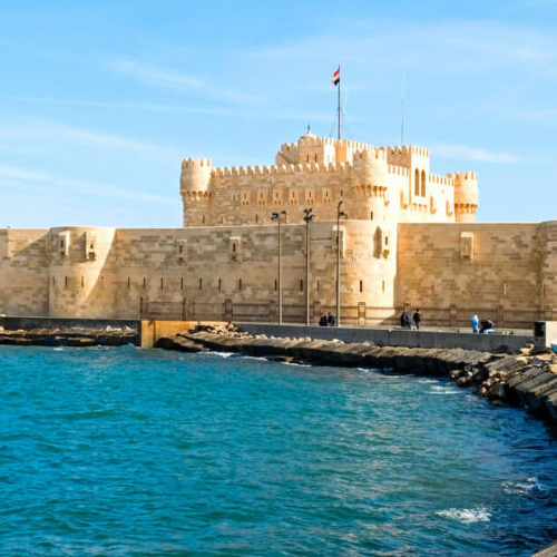The ancient Qaitbay Citadel in Alexandria, Egypt, standing against a clear blue sky.