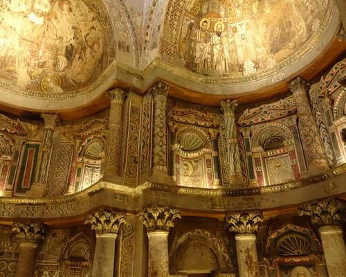 Intricate mosaics and frescoes adorning the apse and dome inside a historical church